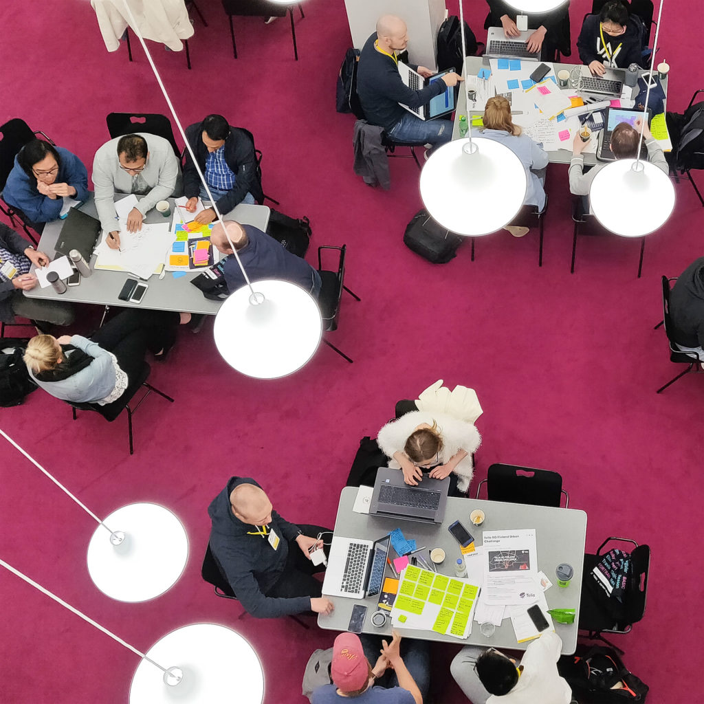 Top view of 3 groups of people ideating on tables.