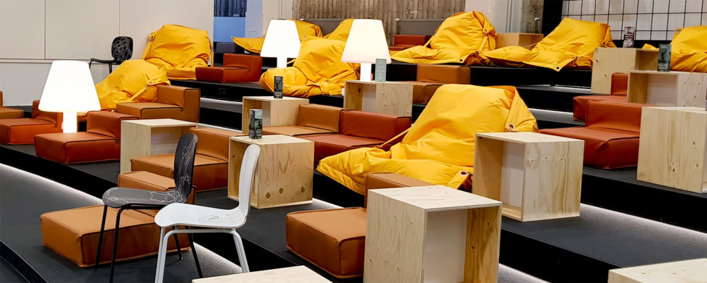 A Grid Mordor-space lounge area with yellow fatboy chairs and white lamps.