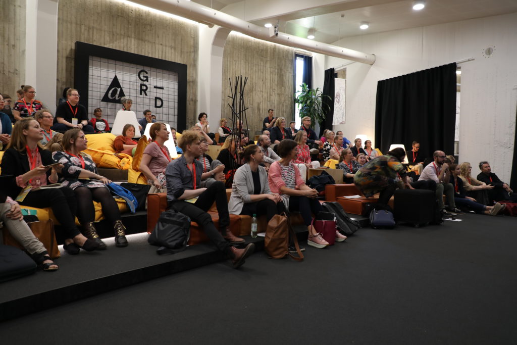 Learning@Aalto guests sitting in Mordor lounge at AGrid while listening to speakers