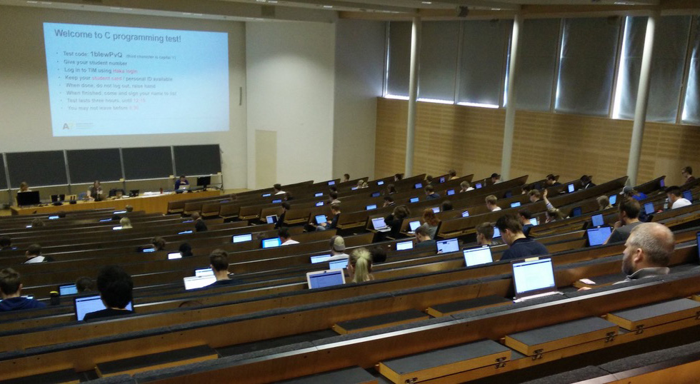 Students taking an exam in an auditorium.